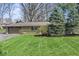 Well-maintained front yard with green grass, mature trees, and shrubbery at 10129 Guilford Ave, Carmel, IN 46280
