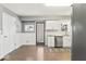 Open kitchen area featuring stainless dishwasher, white cabinets, a door to outside, and wood floors at 10129 Guilford Ave, Carmel, IN 46280