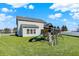 Wide open backyard featuring a play set, green grass, and other homes nearby at 10465 Long Branch Dr, Brownsburg, IN 46112