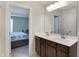 Bathroom featuring a double sink vanity with framed mirror and doorway to bedroom at 10465 Long Branch Dr, Brownsburg, IN 46112