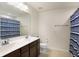 Well lit bathroom with double sinks, and a combined shower and tub with striped curtain at 10465 Long Branch Dr, Brownsburg, IN 46112