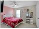 This bedroom has a pink accent wall, a white bed with pink covers and a makeup vanity at 10465 Long Branch Dr, Brownsburg, IN 46112