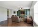 Open-concept living room with dark wood floors, built-in storage, and a connecting kitchen at 10465 Long Branch Dr, Brownsburg, IN 46112