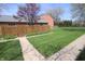 The lush green backyard shows a path of concrete blocks, a lawn, and a wood fence at 1121 Canterbury Ct, Indianapolis, IN 46260