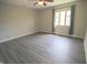 A bright bedroom features gray flooring, a ceiling fan, and a sunny window with neutral walls at 1121 Canterbury Ct, Indianapolis, IN 46260