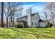 View of the home's backyard featuring a lawn, mature trees, screened porch, and a neutral-toned exterior at 11249 Tall Trees Dr, Fishers, IN 46038