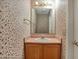 Charming powder room with decorative floral wallpaper, classic vanity, and well-lit mirror for added convenience at 11249 Tall Trees Dr, Fishers, IN 46038