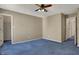 Bedroom with plush blue carpet, soft neutral walls, and ample doorway space, offering a comfortable retreat at 11249 Tall Trees Dr, Fishers, IN 46038