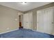 Bedroom featuring soft blue carpet, neutral paint, and convenient closet space for ample storage solutions at 11249 Tall Trees Dr, Fishers, IN 46038