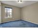 Cozy bedroom with neutral paint, plush blue carpet, and a bright window offering natural light and a pleasant view at 11249 Tall Trees Dr, Fishers, IN 46038