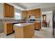 Well-lit kitchen featuring light wood cabinetry, a center island, and a window over the sink with backyard views at 11249 Tall Trees Dr, Fishers, IN 46038
