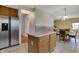 Eat-in kitchen with light wood cabinetry and island, with views into a carpeted living area and access to the hallway at 11249 Tall Trees Dr, Fishers, IN 46038