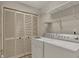 Bright laundry room featuring a white washer and dryer, with added shelving for storage and organization at 11249 Tall Trees Dr, Fishers, IN 46038