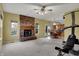 Carpeted living room features a brick fireplace and adjoins a dining area and kitchen in an open-concept layout at 11249 Tall Trees Dr, Fishers, IN 46038