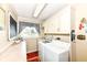 Bright laundry room featuring cabinetry, modern washer and dryer, countertop space, and a window at 1153 Diablo Rd, Greenwood, IN 46143