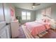 Cozy bedroom with pink bedding, white furniture, and a colorful patterned rug at 12332 Cobblefield Ct, Fishers, IN 46037