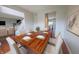 Dining room with hardwood floors, dining table with seating for six, and view into kitchen at 12332 Cobblefield Ct, Fishers, IN 46037