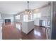 Bright, open kitchen with white cabinets, stainless steel appliances and an island extending to the living room at 12332 Cobblefield Ct, Fishers, IN 46037