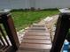 Wooden steps to deck with welcome mat, looking out over a grassy yard with flowers at 13065 Allman Dr, Mooresville, IN 46158