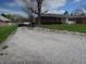 Gravel driveway leading to a brick home with well-manicured lawn and shrubbery at 13065 Allman Dr, Mooresville, IN 46158