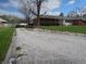 Home exterior showing a long gravel driveway and meticulously maintained lawn surrounded by mature trees at 13065 Allman Dr, Mooresville, IN 46158