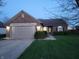 Charming single-story brick home with a well-maintained lawn and attached garage at dusk at 1317 Mulberry Ct, Greenfield, IN 46140