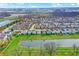 An aerial of neighborhood homes adjacent to a picturesque pond, with manicured lawns and mature trees at 14444 Black Farm Dr, Noblesville, IN 46060