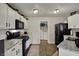 Bright kitchen with white cabinets, granite countertops, and black appliances, including a gas range and microwave at 14444 Black Farm Dr, Noblesville, IN 46060