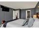 Comfortable main bedroom with a view of the ensuite bathroom with a TV mounted on the wall at 14444 Black Farm Dr, Noblesville, IN 46060