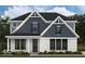 Charming two-story home with white brick and charcoal shingles, offering classic curb appeal and modern design elements at 15087 Covebrook Ln, Fishers, IN 46037