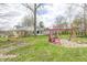 Expansive backyard view showing the house, playground, and lush greenery offering space for Gathering fun at 1527 N Washington St, Danville, IN 46122