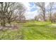 Lush green backyard featuring mature trees and a glimpse of the house, ideal for enjoying nature at 1527 N Washington St, Danville, IN 46122