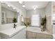 Elegant bathroom featuring a tiled bathtub and shower, white vanity with sink, and natural lighting at 1527 N Washington St, Danville, IN 46122
