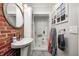 Bathroom showcasing brick accent wall, vessel sink, white storage cabinet and an open shower stall at 1527 N Washington St, Danville, IN 46122