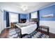 A blue bedroom features a dark wood bed, ceiling fan and natural light from the room's two windows at 1527 N Washington St, Danville, IN 46122