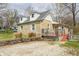 Charming stone house with dormer windows and a gravel driveway, surrounded by mature trees and greenery at 1527 N Washington St, Danville, IN 46122