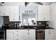 White kitchen cabinets complement the black countertops and stainless steel appliances, and mosaic backsplash at 1527 N Washington St, Danville, IN 46122