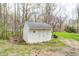 Well-maintained white storage shed nestled among mature trees, providing ample outdoor storage at 1527 N Washington St, Danville, IN 46122