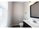 Compact powder room features modern black vanity, toilet, mirror and window with blinds at 1534 Cloverdon Dr, Westfield, IN 46074