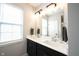 Bathroom showcasing double sinks, dark cabinets, a large mirror, and a bright window at 1534 Cloverdon Dr, Westfield, IN 46074