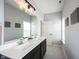 Bathroom featuring a double sink vanity with a decorative plant, tiled floor, and wall decor at 1534 Cloverdon Dr, Westfield, IN 46074