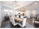 Open concept dining room featuring wood floors, modern light fixture, and views to kitchen and entryway at 1534 Cloverdon Dr, Westfield, IN 46074