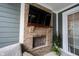 A brick fireplace with a wooden mantel and mounted TV in an outdoor living area, perfect for relaxation at 1534 Cloverdon Dr, Westfield, IN 46074