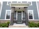 Close-up of a gray front door flanked by wooden pillars and classic rocking chairs at 1534 Cloverdon Dr, Westfield, IN 46074