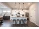 A granite island with pendant lighting and seating, complete with modern appliances, enhances the stylish, white kitchen design at 1534 Cloverdon Dr, Westfield, IN 46074
