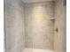 Tiled walk-in shower with glass door and chrome fixtures, featuring a built-in shelf at 1534 Cloverdon Dr, Westfield, IN 46074