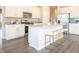 Bright kitchen featuring white cabinetry, stainless steel appliances, and a central island with bar stools at 1571 Beyers St, Fortville, IN 46040
