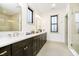 Modern bathroom boasts double sinks, sleek vanities, quartz countertops, and luxurious glass-enclosed shower at 1818 Central Ave, Indianapolis, IN 46202