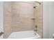 Updated bathroom with a bathtub, neutral tile surround, a brushed gold shower head, and updated fixtures at 1822 Central Ave, Indianapolis, IN 46202