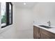 Bright laundry room featuring a modern vanity, black framed window, and tile flooring at 1822 Central Ave, Indianapolis, IN 46202